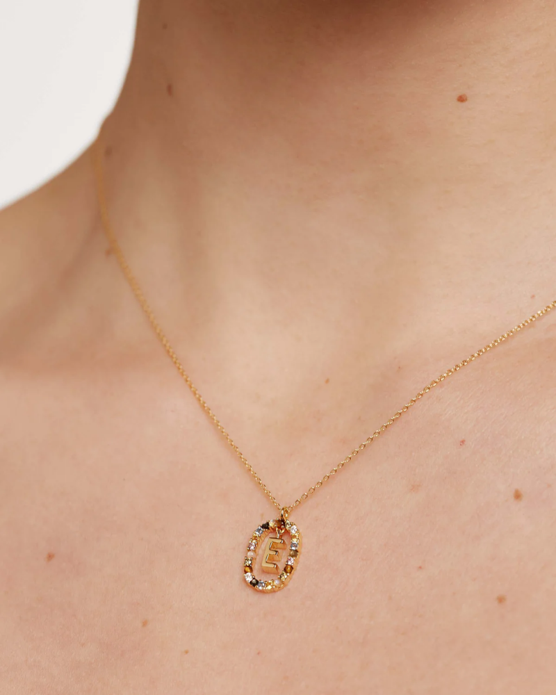 Gold necklace with a pendant on a person's neck