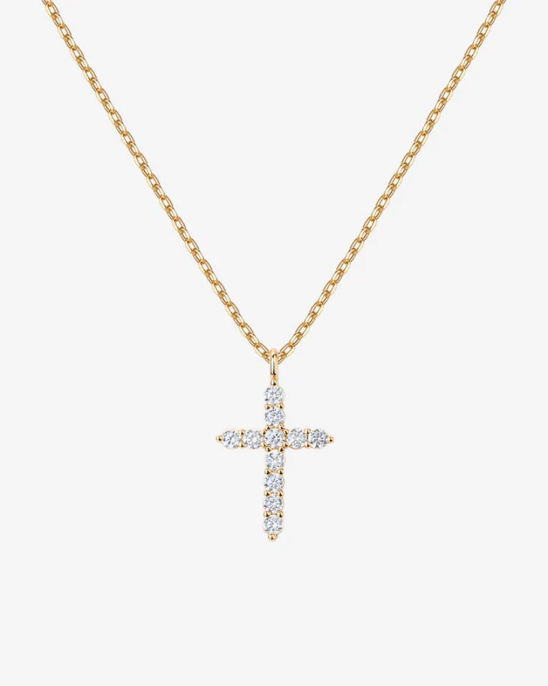 Gold necklace with a diamond cross pendant on a white background
