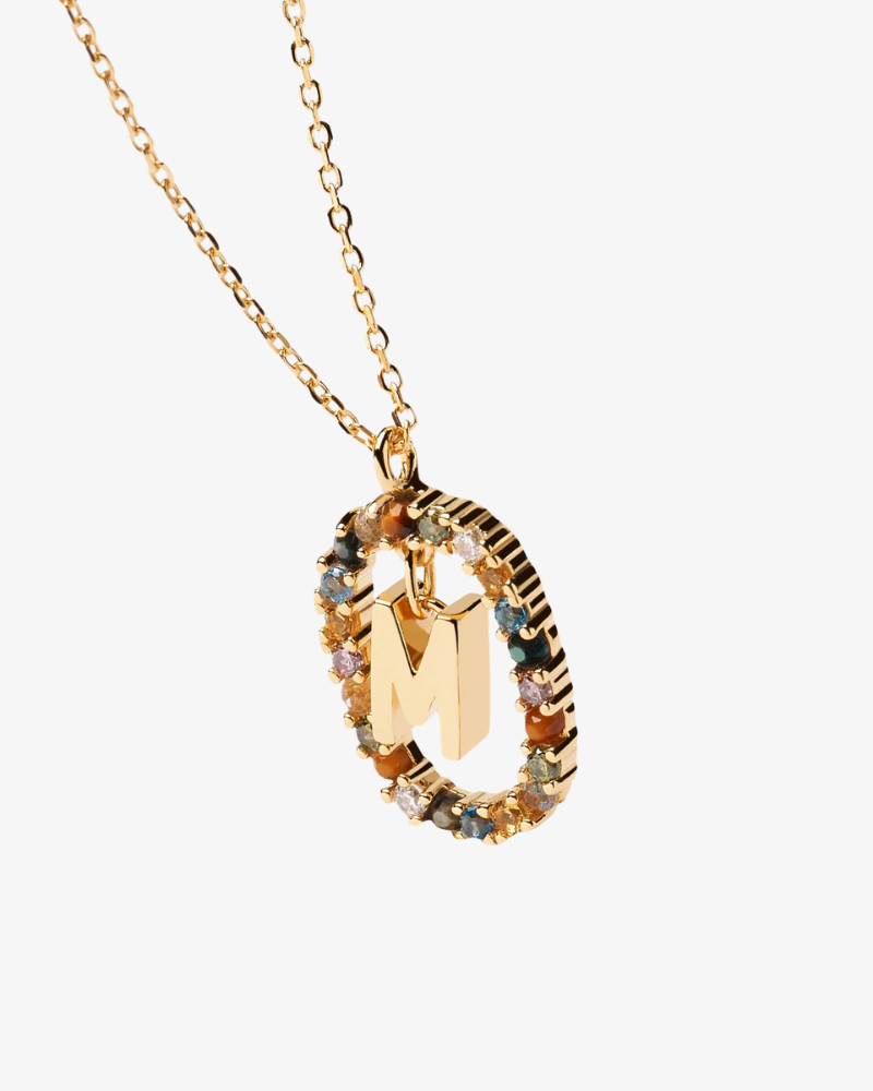 Gold necklace with a pendant featuring the letter 'M' on a white background