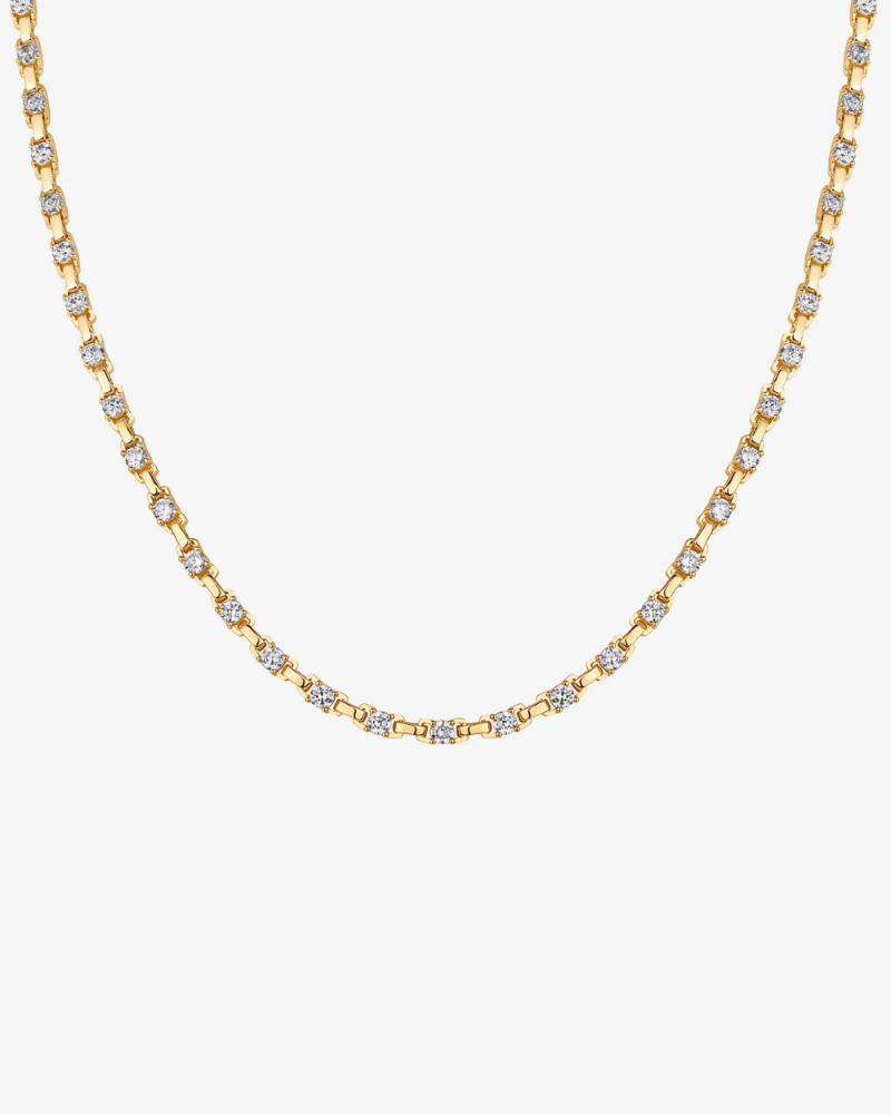 Gold necklace with diamond-like stones on a white background