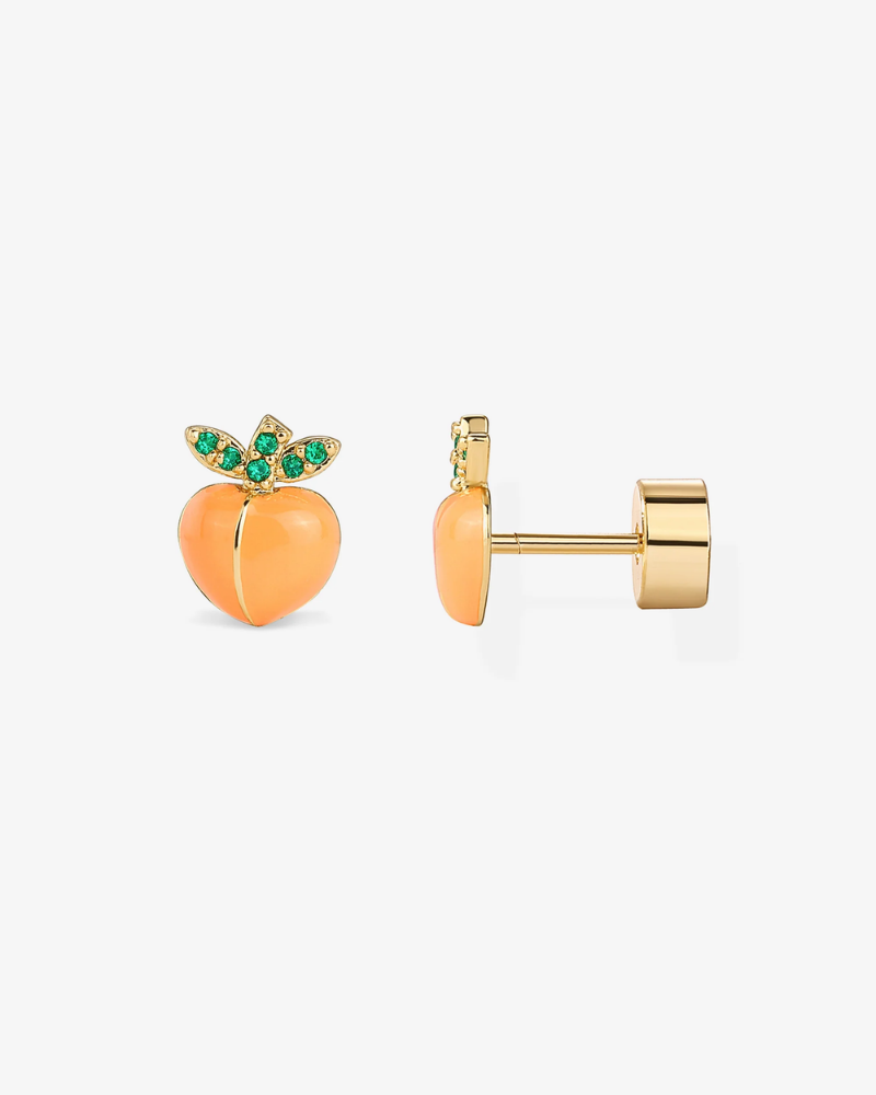 Gold and peach-colored earrings with green gemstones on a white background